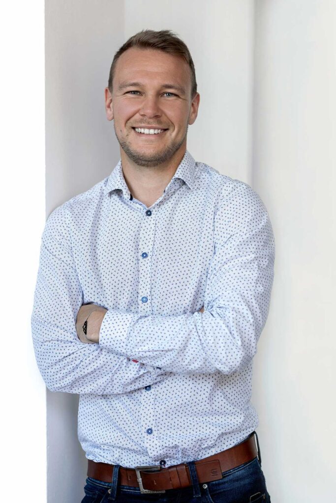 Oliver Hahn lehnt mit rechter Schulter an die Wand